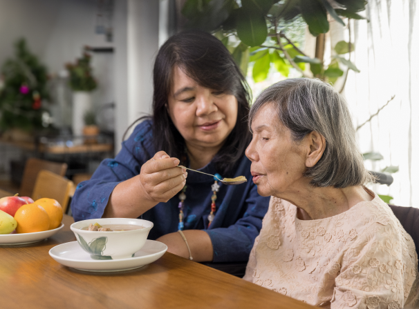 Woman feeding the older person